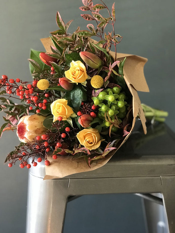 fall wrapped subscription bouquet in golden yellow, red, and green